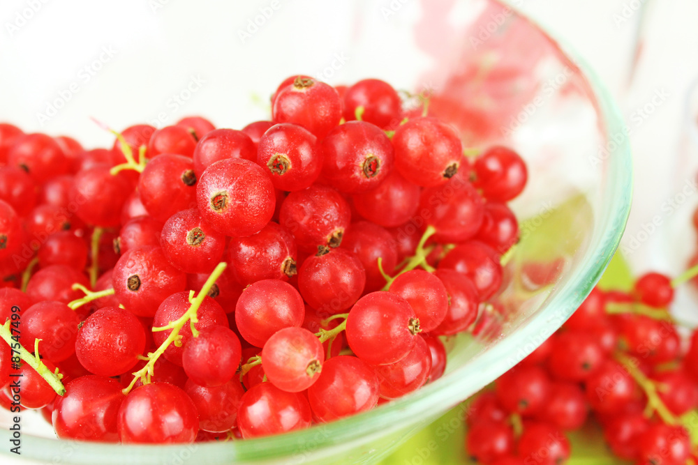 Johannisbeeren in Schale aus Glas und auf Esstisch auf grüner Serviette Johannisbeeren in Schale aus Glas und auf Esstisch auf grüner Serviette