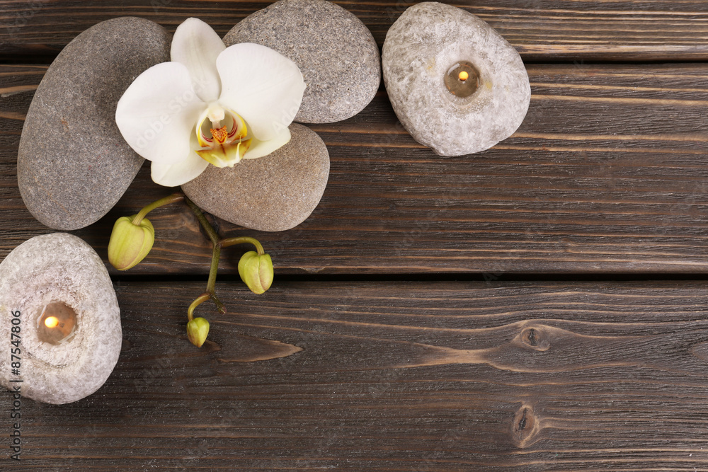 Spa stones and orchid flower on wooden background Spa stones and orchid flower on wooden background