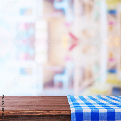 Empty wooden table with napkin on light background
