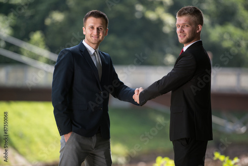 Two Business People Shaking Hands Outdoors