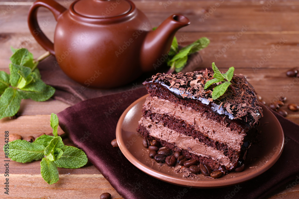 Delicious chocolate cake with mint on plate on table close up Delicious chocolate cake with mint on plate on table close up