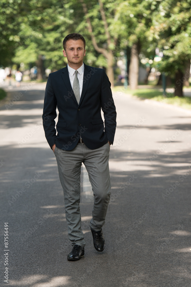 Young Business Man Walking Outdoors In Park Young Business Man Walking Outdoors In Park