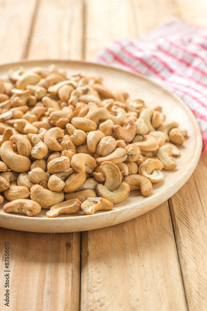 Salty cashew nuts in wooden plate Salty cashew nuts in wooden plate