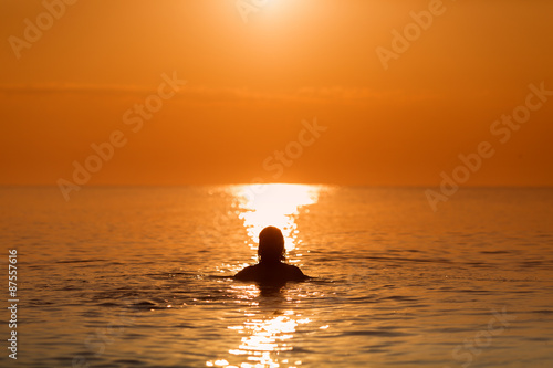 Man in Water on a sea in a sunrise