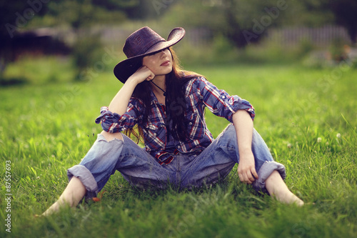 Happy American woman in a cowboy hat field wild flowers