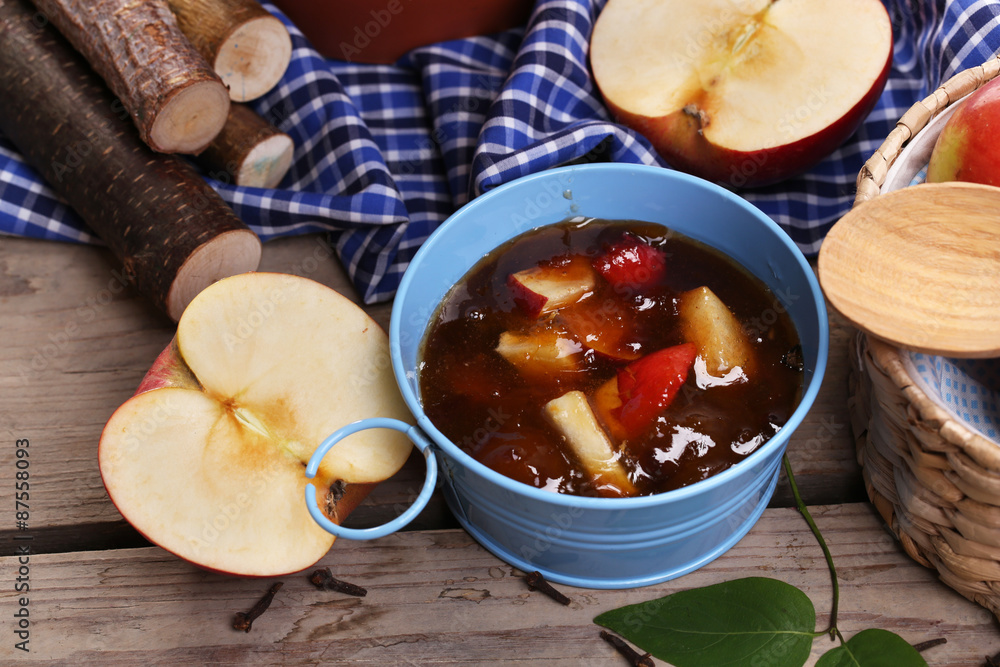 Apple jam in pail and fresh red apples on wooden table close-up Apple jam in pail and fresh red apples on wooden table close-up