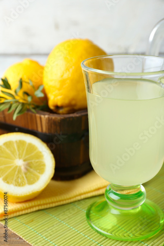 Still life with lemon juice and sliced lemons n wooden table, closeup