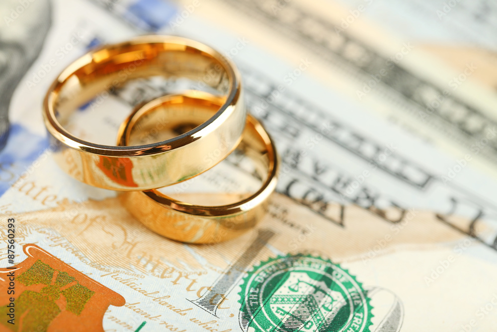 Golden wedding rings on banknotes background. Marriage of convenience Golden wedding rings on banknotes background. Marriage of convenience