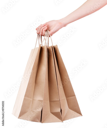 Female hand holding paper shopping bag isolated on white