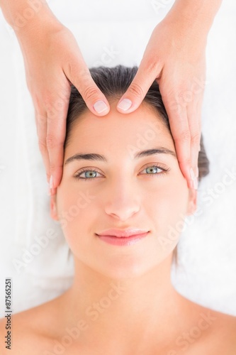 Attractive young woman receiving head massage at spa center