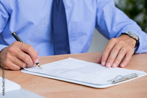 Businessman signing a contract in the office