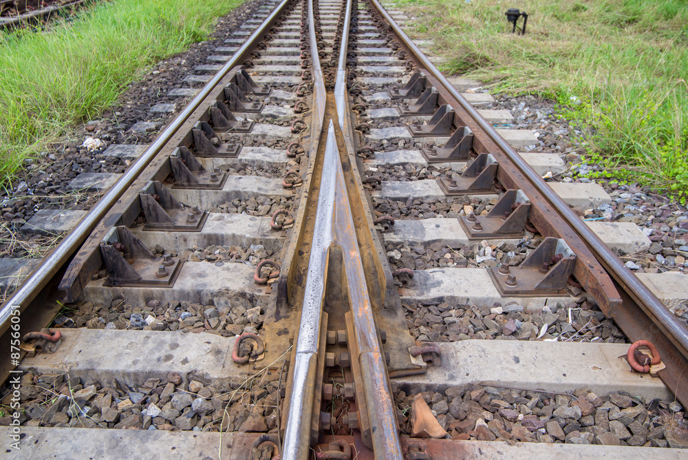 railroad tracks with railroad switch, two paths come together