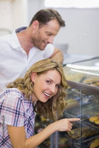 Portrait of a smiling blonde woman looking at pastry 