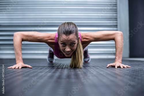 Muscular woman doing push ups