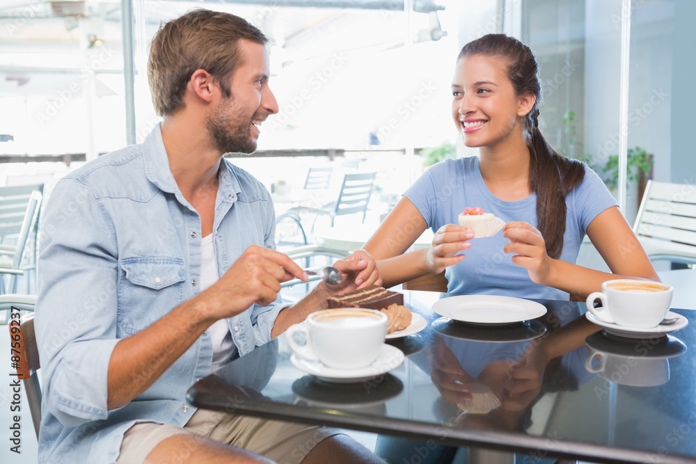 Young happy couple eating cake together Young happy couple eating cake together