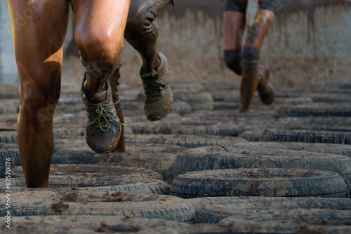 Mud race runners, tries to make it through the tire trap photo