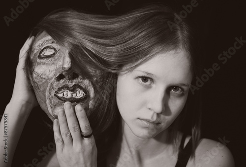Fototapeta Naklejka Na Ścianę i Meble -  Portrait of a young woman with spooky theatrical mask