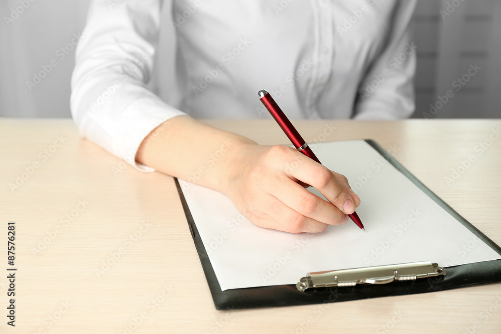 Businesswoman writing on document Businesswoman writing on document