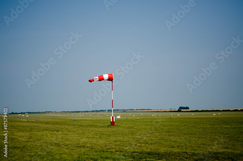 Airfield wind direction sign on the green grass with blue sky ba