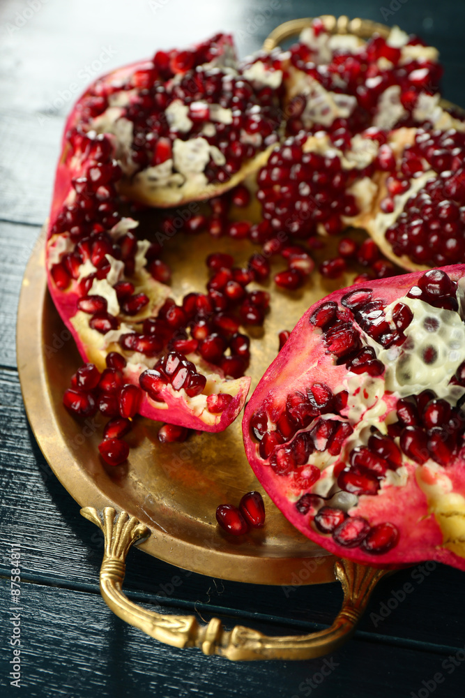 Pomegranate seeds on metal tray on wooden table, closeup Pomegranate seeds on metal tray on wooden table, closeup