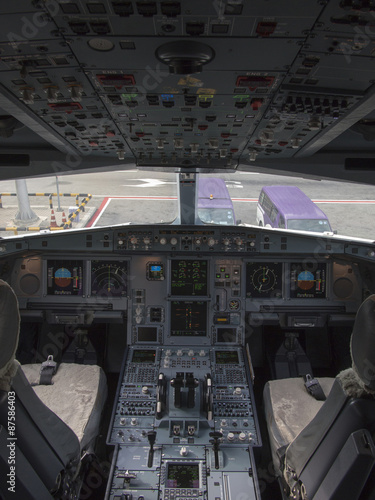 Airbus A330 airplane's cockpit with front,overhead and pedestrian panel taken on ground at day time.