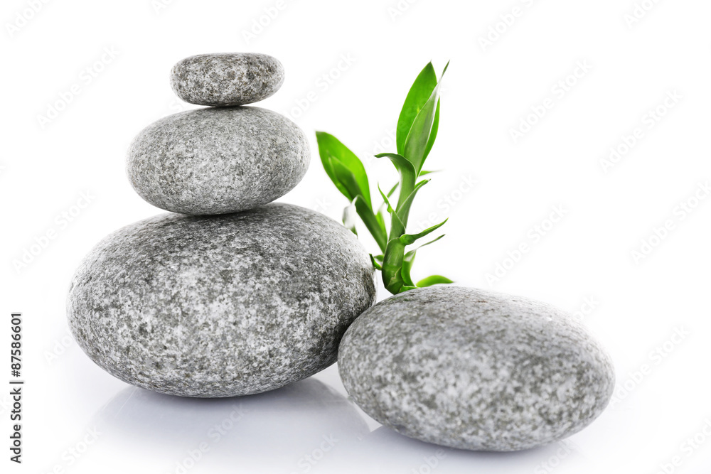 Stack of spa stones with green leaves isolated on white Stack of spa stones with green leaves isolated on white