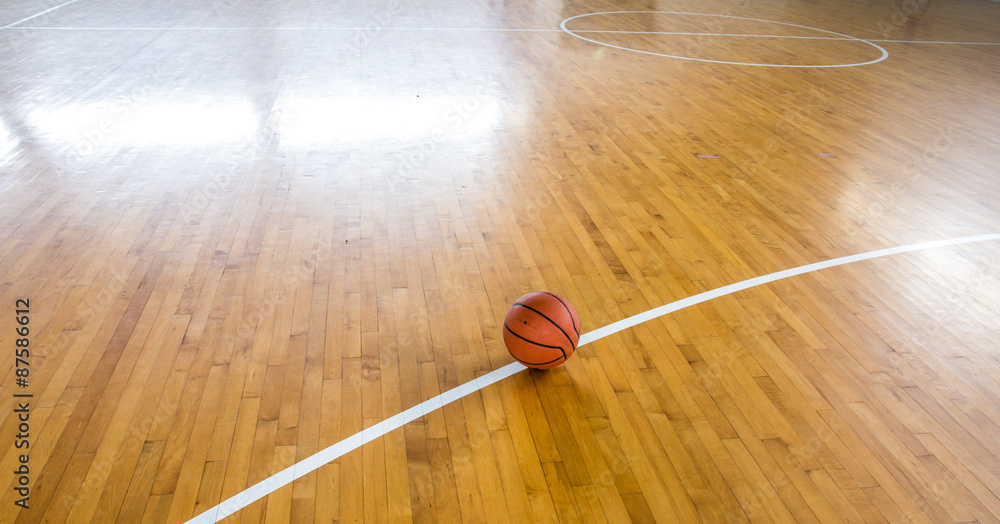 Fototapeta premium Basketball ball over floor in the gym