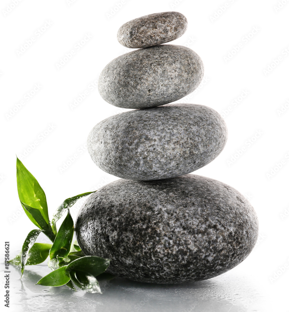 Stack of spa stones with green leaves isolated on white Stack of spa stones with green leaves isolated on white
