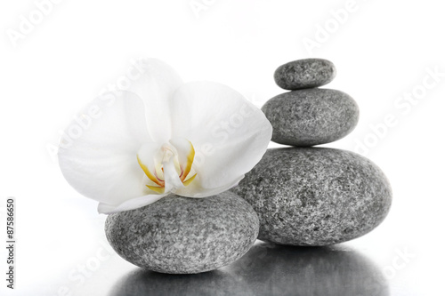 Stack of spa stones with orchid flower isolated on white