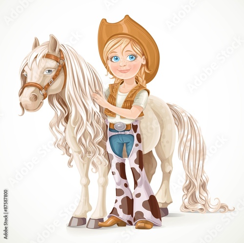 Cute girl dressed as a cowboy holds the reins saddled horse isol