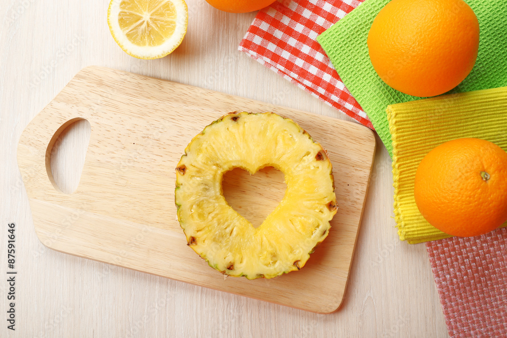 Pineapple slice with cut in shape of heart and different fruits on table close up Pineapple slice with cut in shape of heart and different fruits on table close up