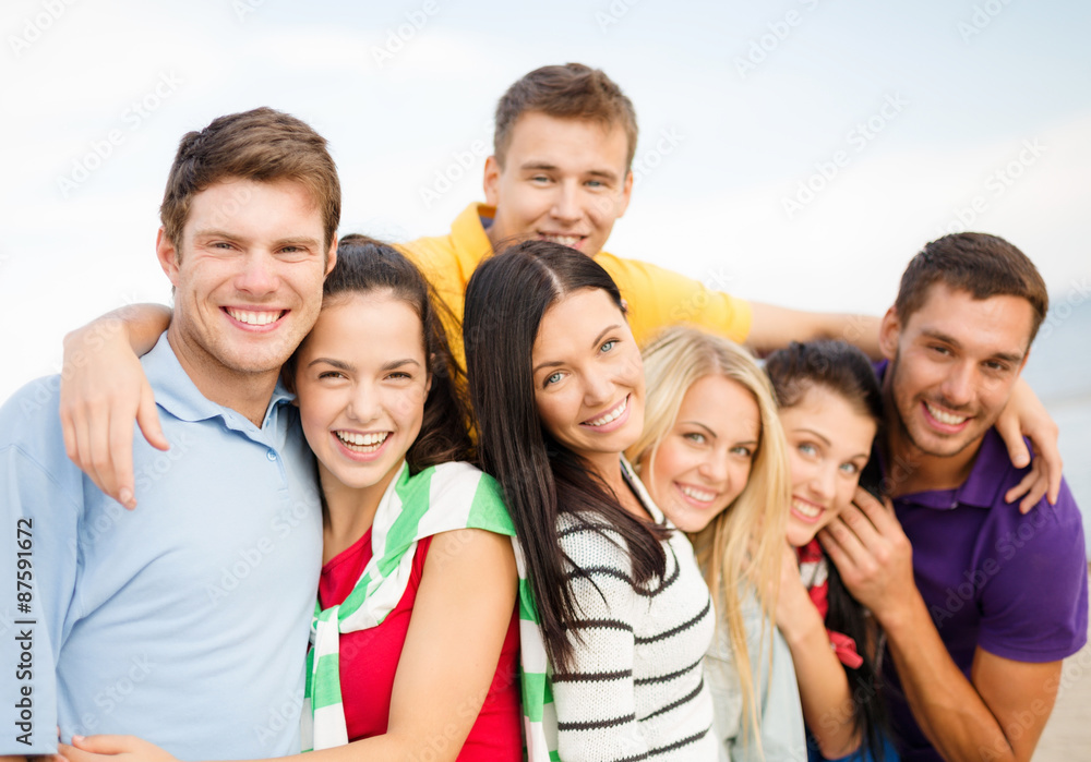 group of happy friends hugging on beach group of happy friends hugging on beach