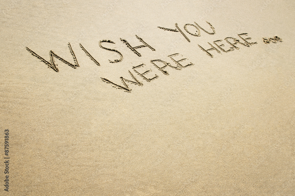 Words wish you were here written in the sand on the beach. Words wish you were here written in the sand on the beach.