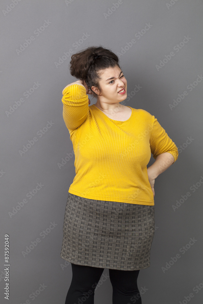 Brunette fat young girl in yellow hoodie and black leggings is