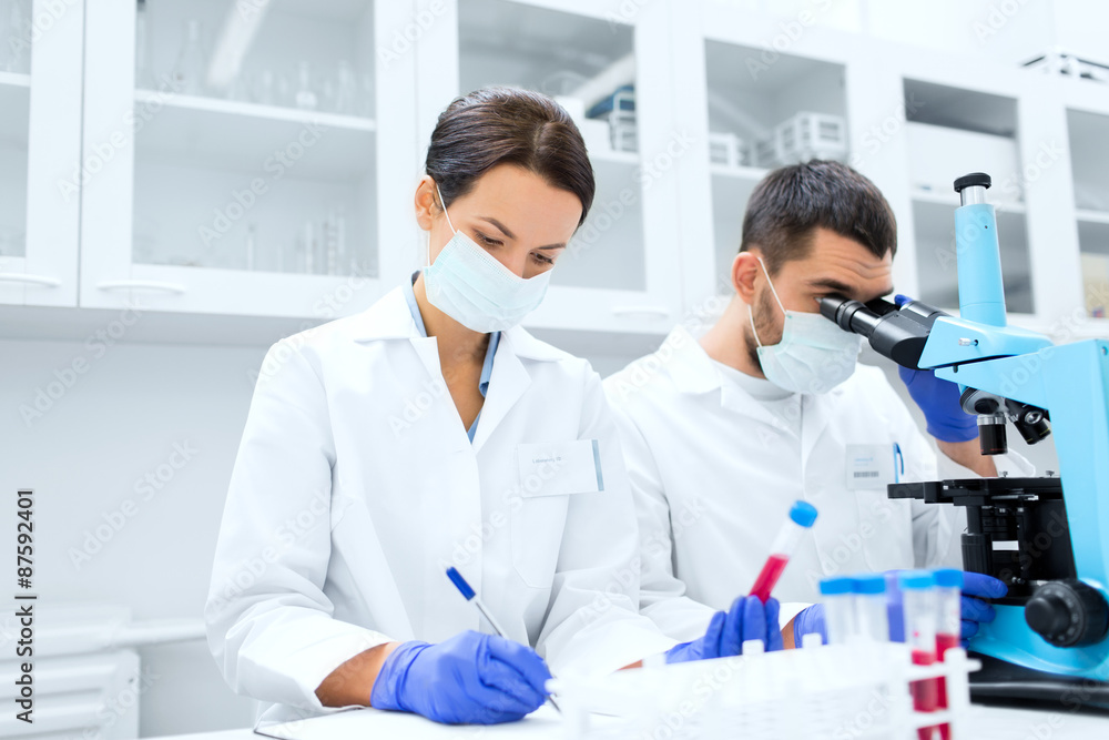 scientists with clipboard and microscope in lab scientists with clipboard and microscope in lab