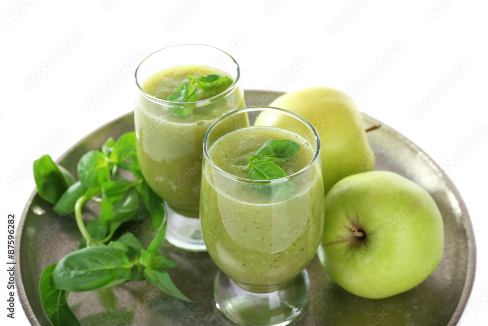 Glasses of green healthy juice with basil and apples on metal tray close up Glasses of green healthy juice with basil and apples on metal tray close up