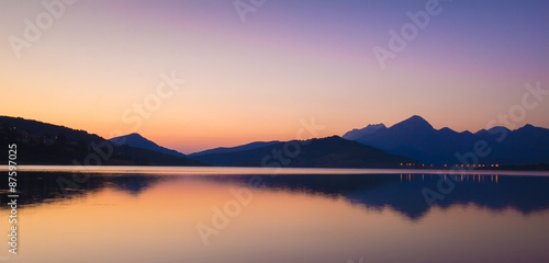 Cime delle montagne riflesse nel lago photo