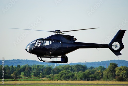 Schwarzer Hubschrauber im Flug dicht über dem Boden