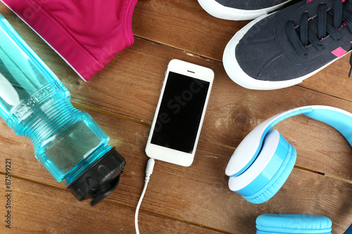 Sport shoes and clothes on wooden background