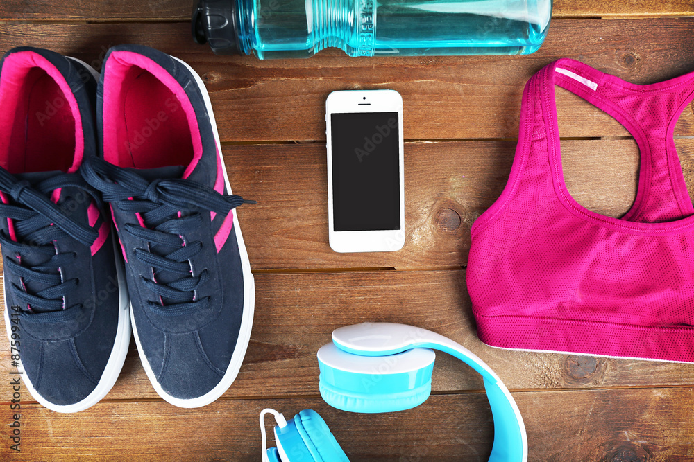Sport shoes and clothes on wooden background Sport shoes and clothes on wooden background