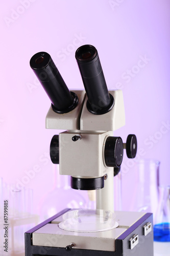 Test tubes and microscope on bright background