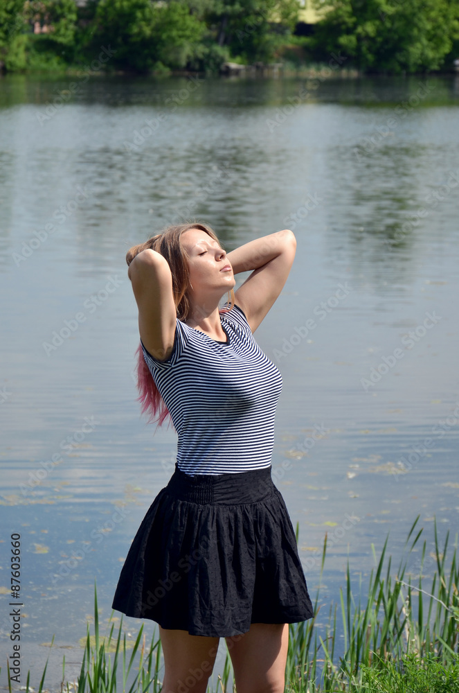 The girl near the river sunbathing The girl near the river sunbathing