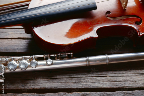 Flute with violin on table close up