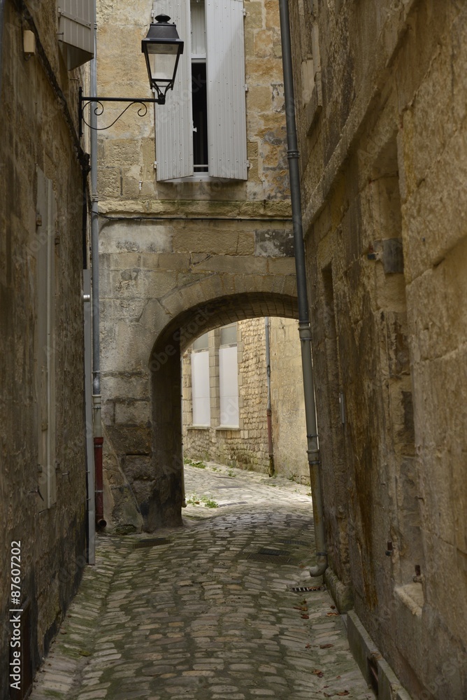 Ruelle en style médiévale passant sous une maison à Saintes