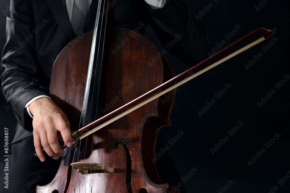 Man playing on cello on dark background Man playing on cello on dark background