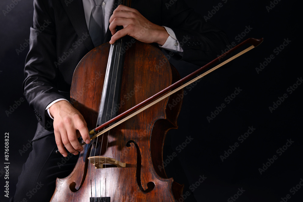 Man playing on cello on dark background Man playing on cello on dark background