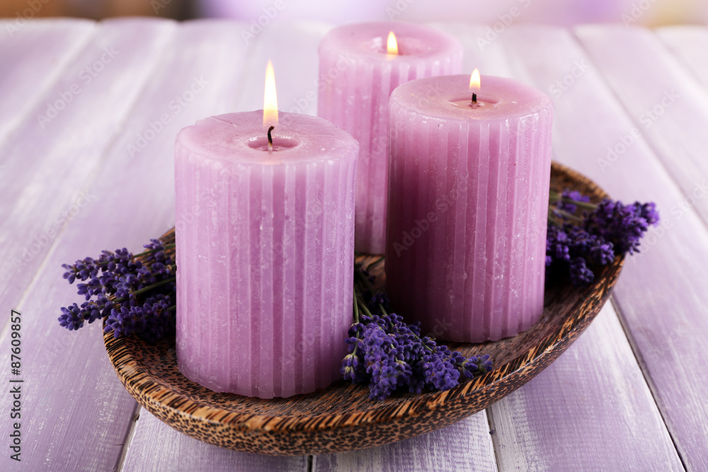 Fototapeta premium Candles with lavender flowers on table close up