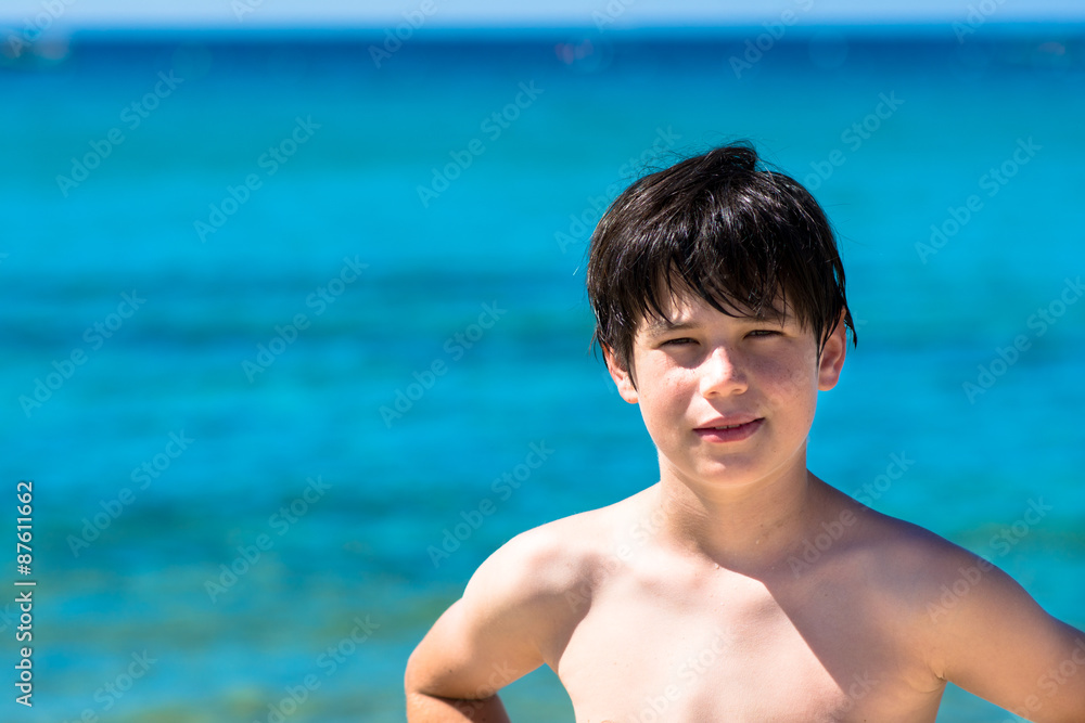 Young boy playing at sea, blue sea background Young boy playing at sea, blue sea background