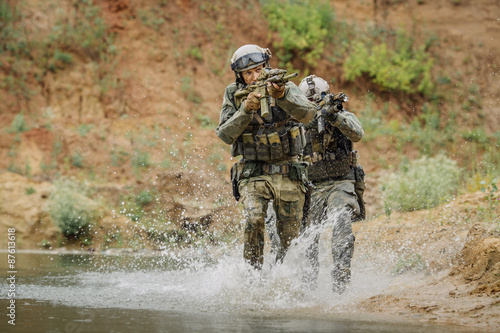 Military team crossing the river under fire