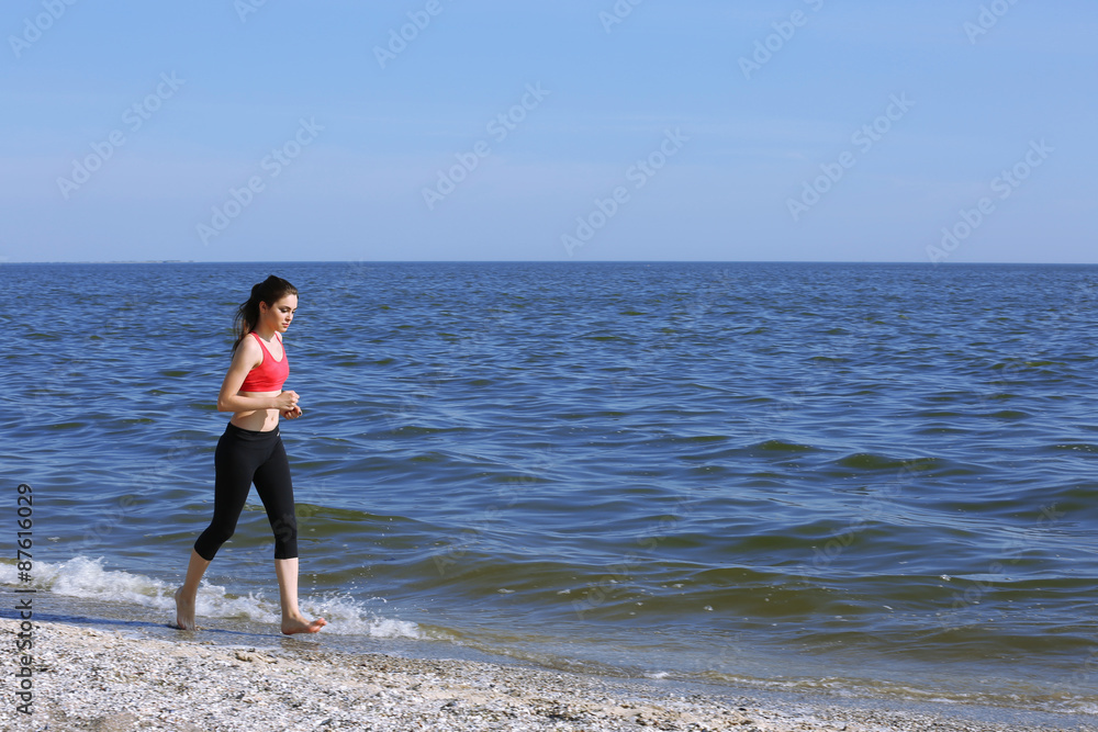 Young woman jogging on beach